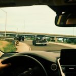 View from a car interior driving on a highway with motorcycles in sight.