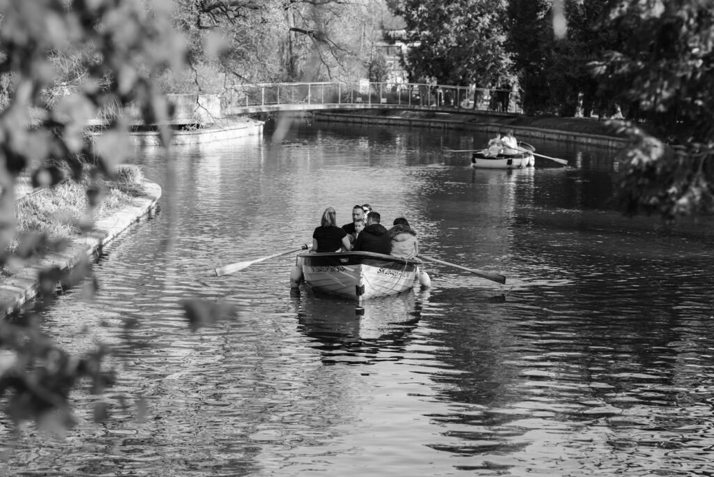Couples enjoying a tranquil boat ride on a peaceful canal in Zagreb, surrounded by lush nature.