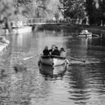 Couples enjoying a tranquil boat ride on a peaceful canal in Zagreb, surrounded by lush nature.