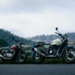 Motorcycles parked against a misty mountain backdrop during a road journey.