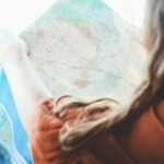A young woman studies a map, planning her road trip adventure.